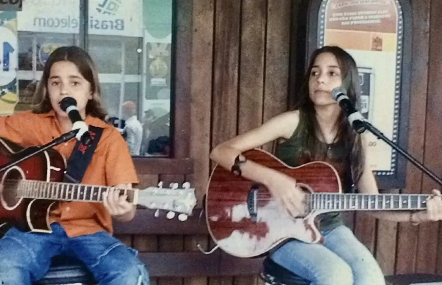 Mariana e Mateus crianças cantando com violões
